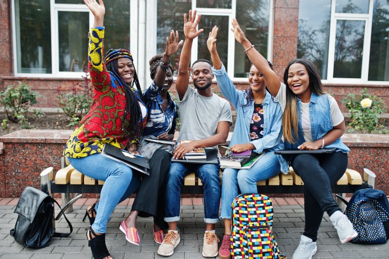Group of five african college students spending time together on